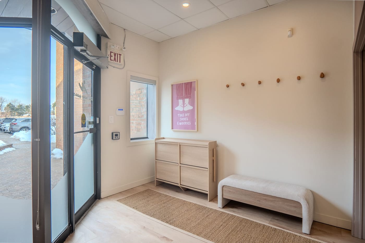 The entry, with cubbies, a bench, and a take off shoes and worries print