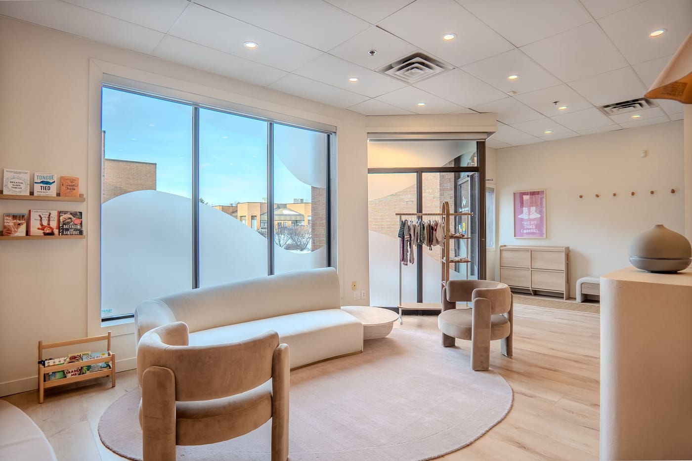 A bright waiting area with soft seating, a reading ledge, and large windows